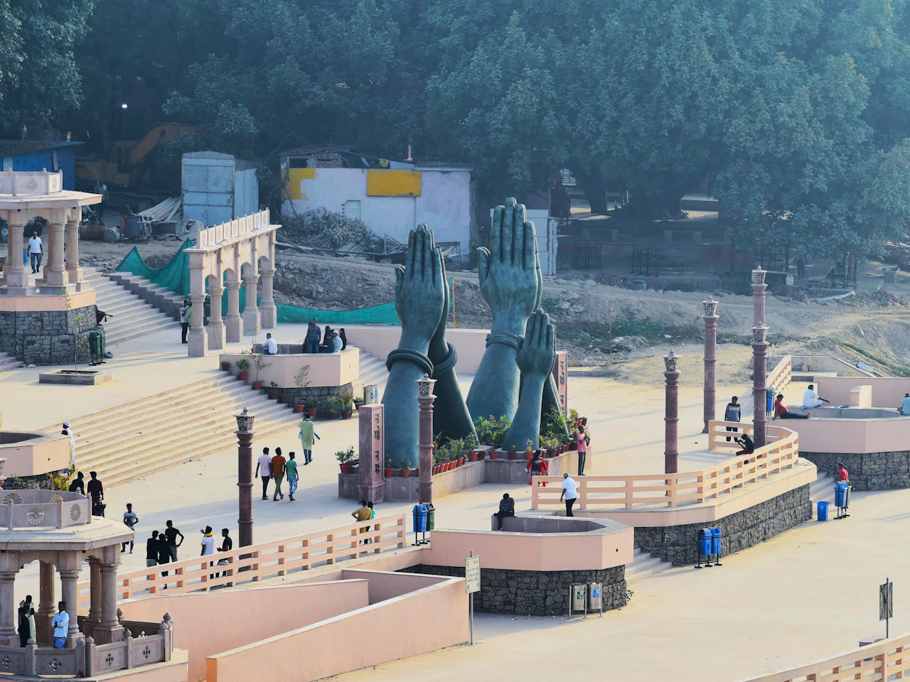 The giant pranam hands sculpture at Namo Ghat, Varanasi, with chhatris and the ghat plaza around it
