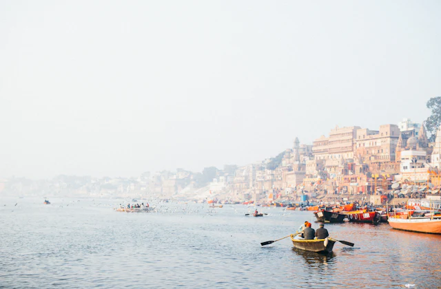 People rowing a boat on the Ganga past the Varanasi riverfront