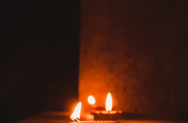 Rows of lighted clay diya lamps glowing against the dark
